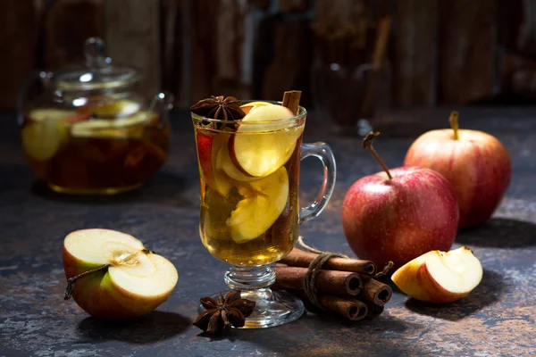 Verre de thé aux pommes chaud avec des épices sur la table noire — Photo