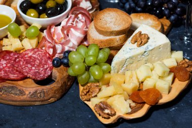 Tahtadaki peynir tabağı, ekmek, meyve ve soğuk kesim, üst görünüm yatay