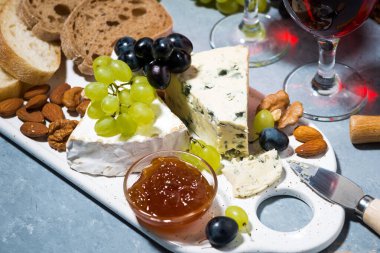 Peynir tabağı, ciabatta, taze üzüm ve kırmızı şarap, üst görünüm yatay.