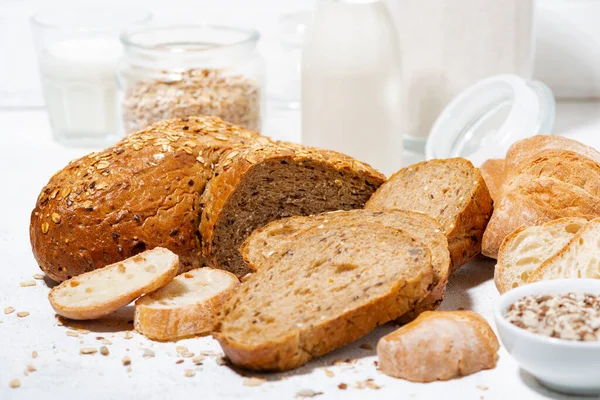 Assorted Fresh Bread Oats Seeds Cut Slices White Table Closeup — Stock Photo, Image