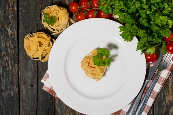 木のテーブルの上に白いプレートとパスタと野菜のテーブルセッティング — ストック写真