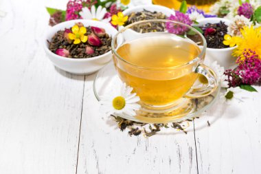 Beyaz ahşap arka planda, yatay olarak kokulu bitki çayı.