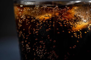 Siyah arka planda buzlu bir bardak Coca Cola, yatay yakın plan