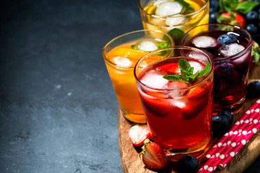 Soğuk meyve ve meyveli içecekler koyu arka planda çeşitli, yatay yakın çekim