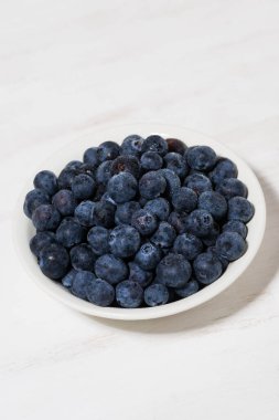 beyaz arka planda taze çiftlik yaban mersinleri, dikey üst görünüm