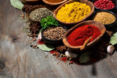 Ahşap bir masa üzerinde çeşitli baharat ve bitkiler, yatay