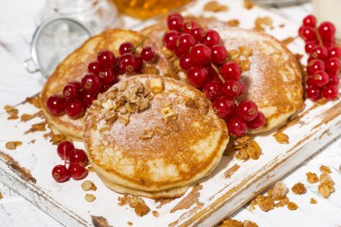 Böğürtlenli ve ballı leziz krepler beyaz tahta üzerinde, yakın yatay.