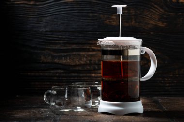 Koyu arka planda çay ve kahve demlemek için boş Fransız presi, yatay