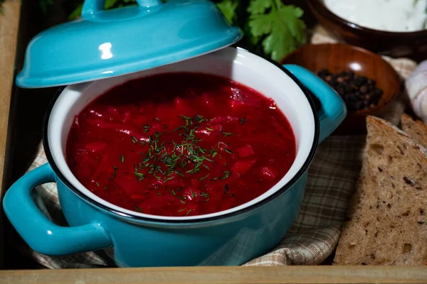 traditional russian dish - fresh borsch with sour cream and dill, top view closeup