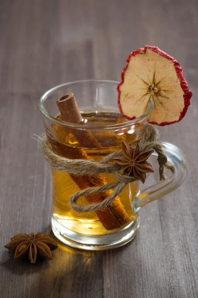 Sidra de manzana especiada en taza de vidrio sobre una mesa de madera, vertical —  Fotos de Stock