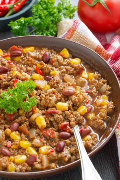 Spicy Mexican dish chili con carne in a brown pottery plate — Stock Photo, Image