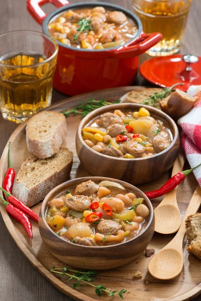 Guisado de legumes com salsichas em uma tigela de madeira, vertical — Fotografia de Stock