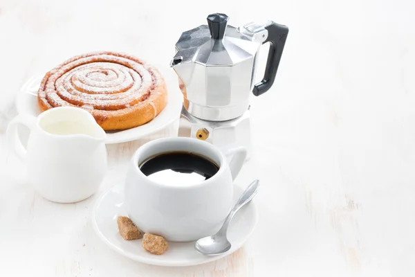 Tasse schwarzen Kaffee, Sahne, süße Semmeln und Kaffeemaschine — Stockfoto