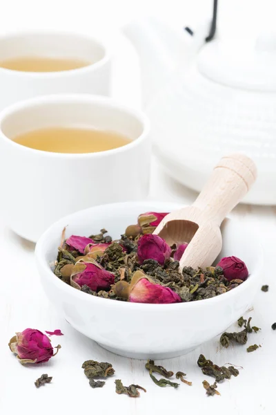 Πράσινο τσάι με μπουμπούκια τριαντάφυλλου, τα κύπελλα και τσαγιέρα, κάθετη — Φωτογραφία Αρχείου