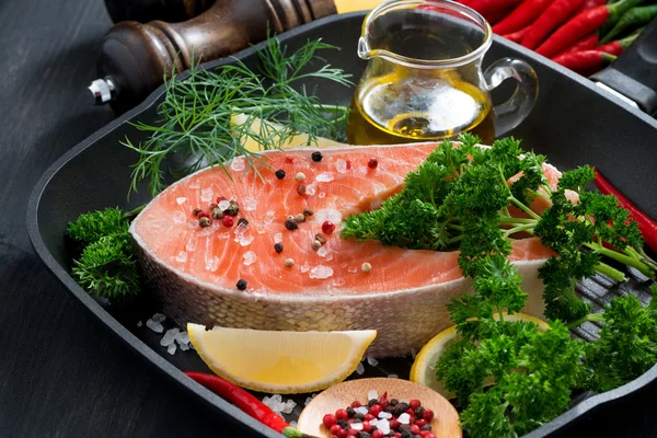 Fresh salmon steak and ingredients for cooking on a grill pan — Stock Photo, Image