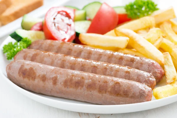 Saucisses grillées aux frites et légumes, gros plan — Photo