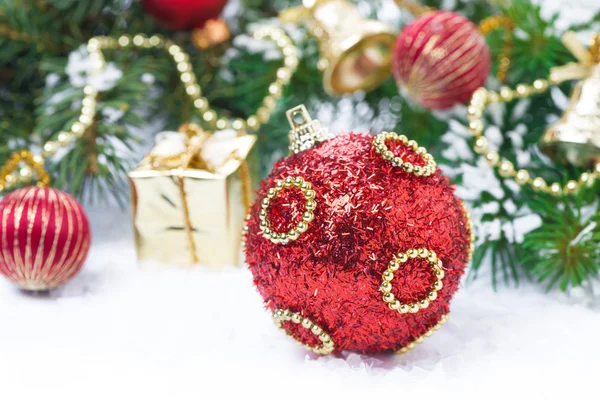 Red Christmas ball with fir branches and decorations — Stock Photo, Image