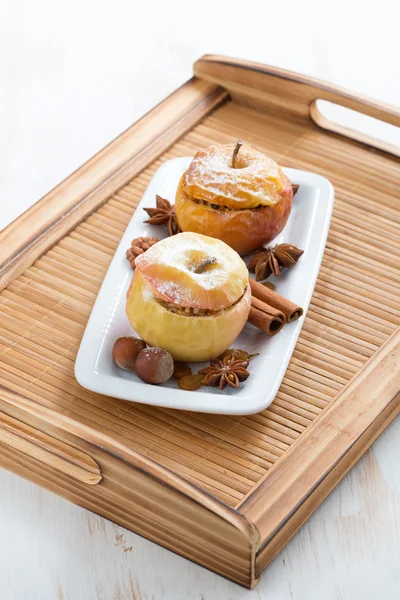 Manzanas rellenas al horno en un plato blanco en bandeja de madera — Foto de Stock