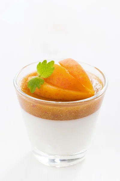 Dessert with cream and apricot jelly in a glass, close-up — Stock Photo, Image