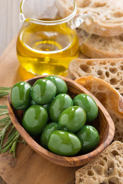 Färska gröna oliver, olivolja och ciabatta, ovanifrån — Stockfoto