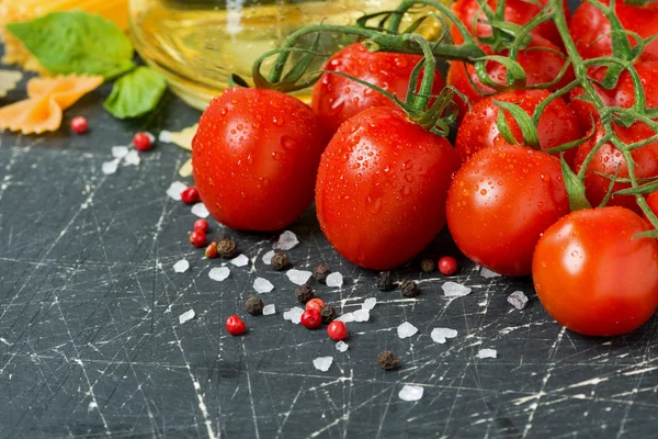 Fundo de madeira escura com tomates cereja e ingredientes — Fotografia de Stock