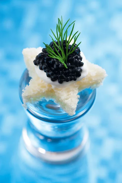 Tartina con caviale nero per Natale su sfondo blu — Foto Stock