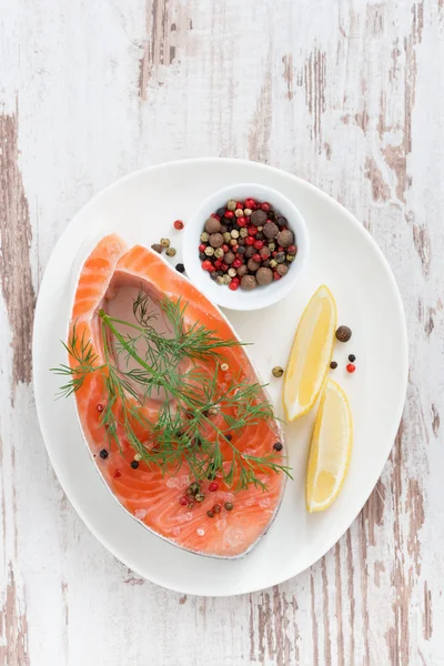 Fresh salmon steak, lemon and pepper on white wooden background — Stock Photo, Image