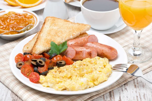 Scramble eggs with tomatoes, sausage and toast on a plate — Stock Photo, Image