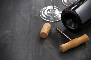 bir şişe kırmızı şarap, tirbuşon ve boş bardak