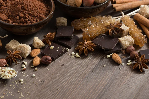 Cacao, cioccolato, noci e spezie su fondo di legno — Foto Stock