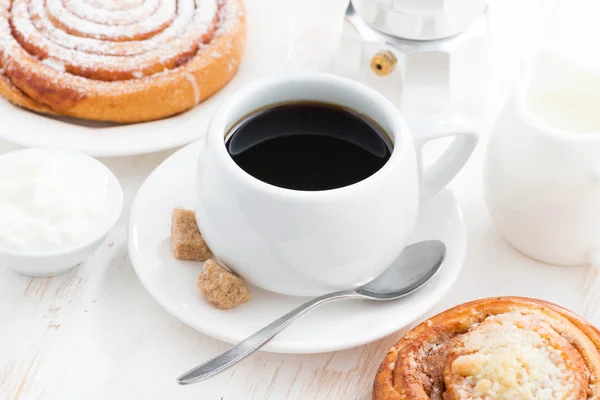 Tasse schwarzen Kaffee und süßes Brötchen zum Frühstück — Stockfoto