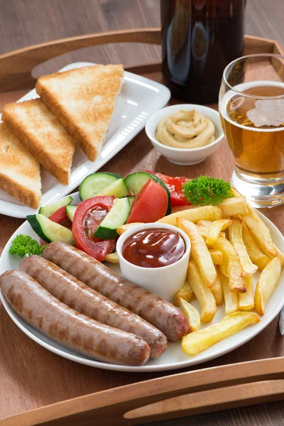 Lunch with grilled sausages with French fries, vegetables, beer — Stock Photo, Image