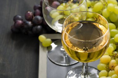 kadeh beyaz şarap ve bir kara tahta üzerinde çeşitli üzüm