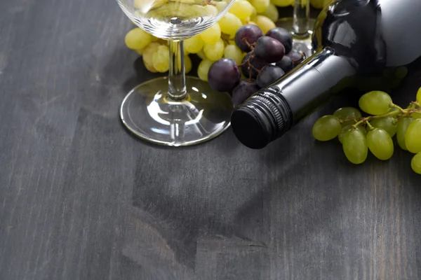 Bottle of red wine, empty glass and grapes — Stock Photo, Image