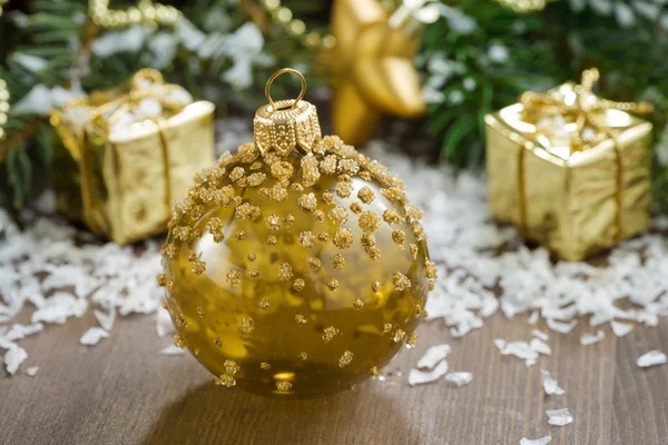 Christmas ball and spruce branches on a wooden background — Stock Photo, Image