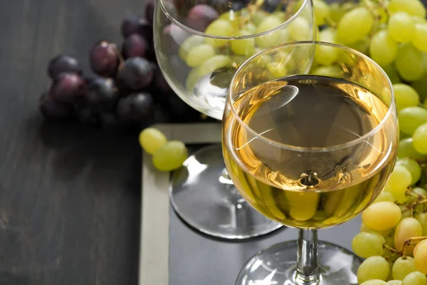 Verre de vin blanc et raisins assortis sur un tableau noir — Photo