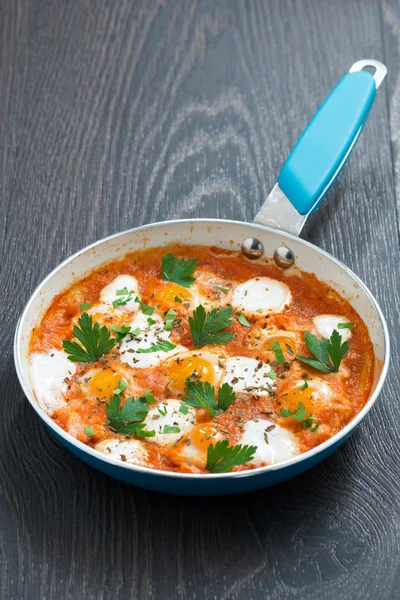 Fried quail eggs in tomato sauce in a frying pan — Stock Photo, Image