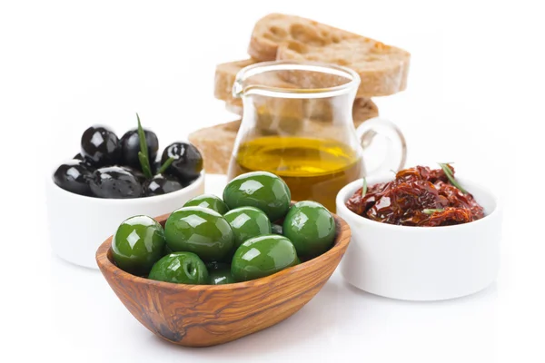 Zelené a černé olivy, sušená rajčata, sklenice s olivovým olejem — Stock fotografie