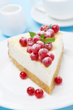 Cheesecake ile plaka üzerinde kırmızı kuş üzümü
