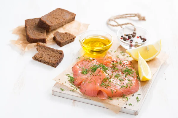 Соль лосось, хлеб и ингредиенты на деревянной доске — стоковое фото