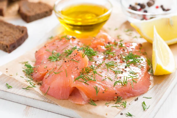 Salted salmon, bread and ingredients on a wooden board, close-up — Stock Photo, Image