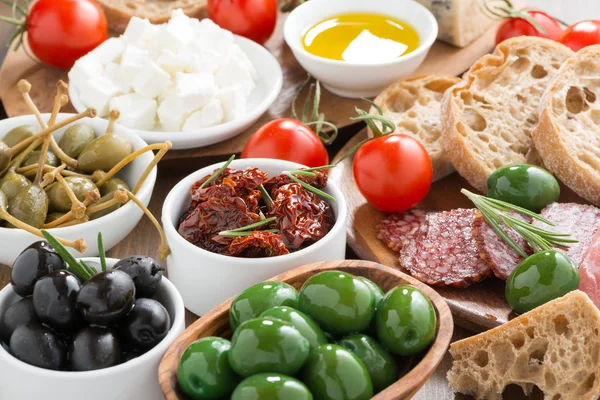 Variados antipasti italianos - aceitunas, salami, encurtidos y pan —  Fotos de Stock