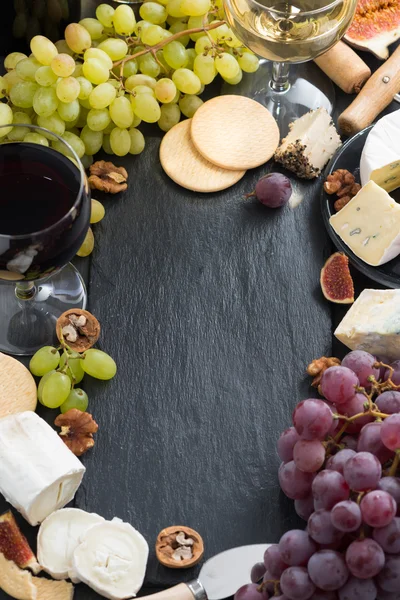 Fondo negro con quesos, uvas, galletas y vino — Foto de Stock