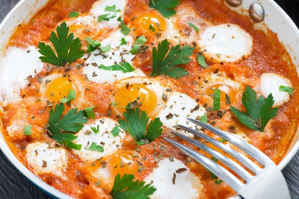 Fried quail eggs in tomato sauce in a frying pan for breakfast — Stock Photo, Image