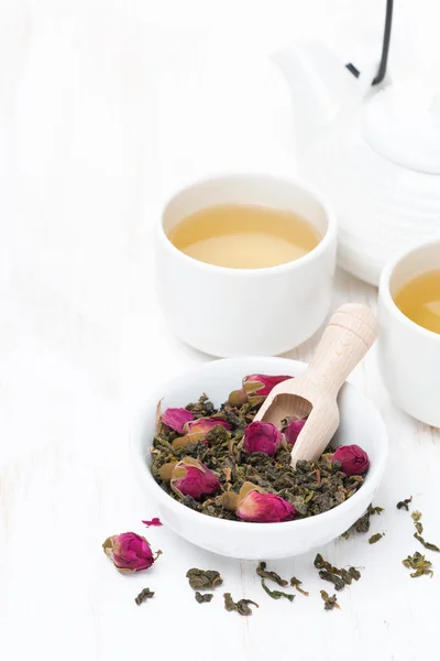 Green tea with rosebuds, cups and teapot on white table — Stock Photo, Image