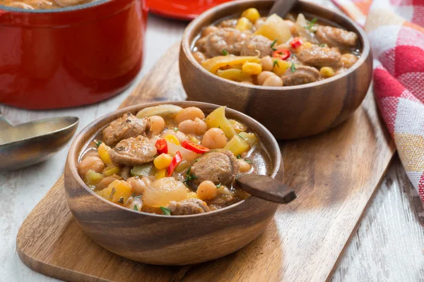 Stufato di verdure con salsicce in una ciotola di legno a bordo — Foto Stock