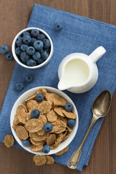 Flocons de grains entiers avec des bleuets et du lait, vue de dessus — Photo