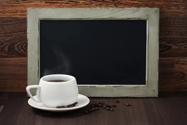 Černý psací deska a šálek kávy s párou — Stock fotografie