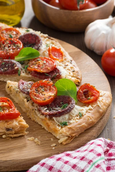 Salam ve ahşap tahta üzerinde domates lezzetli pizza