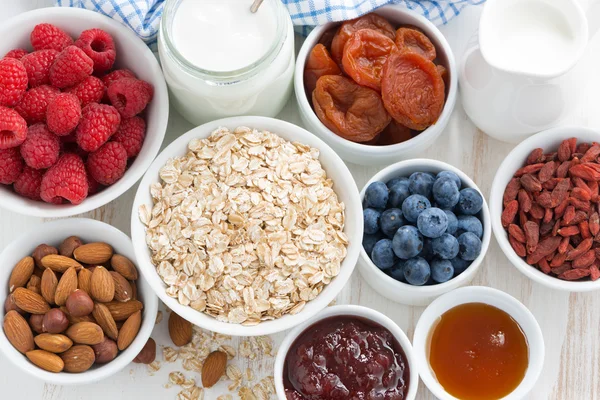 Copos de avena y varios ingredientes deliciosos para el desayuno — Foto de Stock